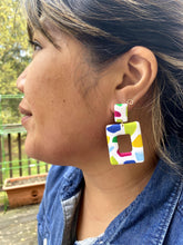 Load image into Gallery viewer, Ezrah wearing Barcelona Square Cut-Out on left ear Barcelona Square Cut-Out 1.125 L x 0.125 W x 2.25 H 18K Gold Plated Surgical Steel Earring Posts Silicone backings by Pinwheel Clay
