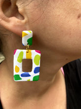 Load image into Gallery viewer, Maggie wearing Barcelona Square Cut-Out on right ear Barcelona Square Cut-Out 1.125 L x 0.125 W x 2.25 H 18K Gold Plated Surgical Steel Earring Posts Silicone backings by Pinwheel Clay
